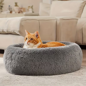 Orange tabby cat resting in gray Donut Cuddler Bed