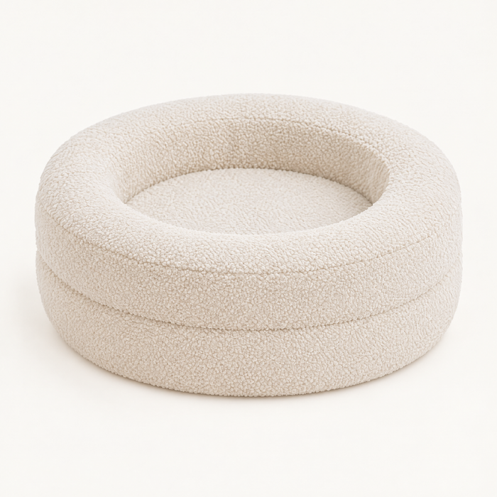 Round oat-coloured teddy fleece cat bed with two-tier raised walls on a plain background