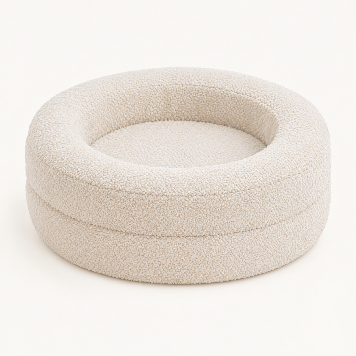 Round oat-coloured teddy fleece cat bed with two-tier raised walls on a plain background
